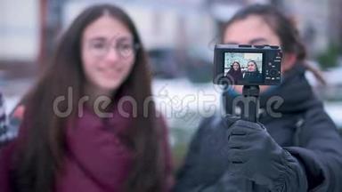 两位深黑肤色的女孩朋友和博客作者在冬季旅行时用<strong>相机录制</strong>视频